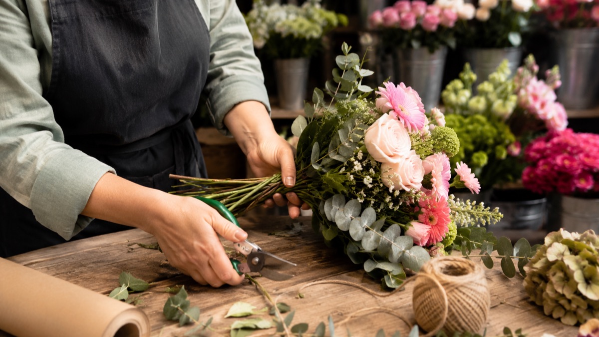 Une fleuriste compose un bouquet dans sa boutique